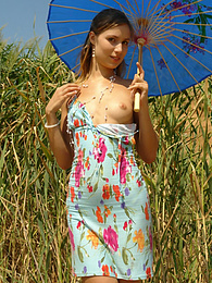FreshPornPics presents: Girl in a light dress strolling outdoors, hiding from the sun under the sunshade and stripping